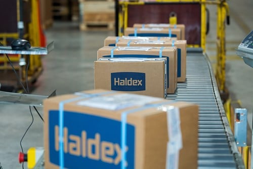 Haldex-branded boxes move along a conveyor belt i, ready for shipment
