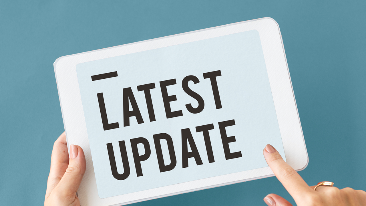 A person holding a screen "Latest update"