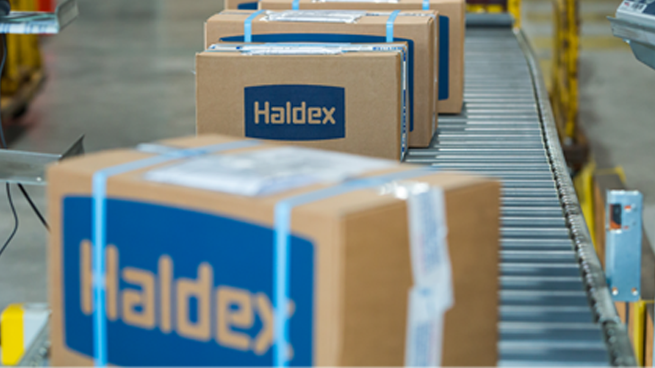 Haldex-branded boxes move along a conveyor belt, ready for shipment
